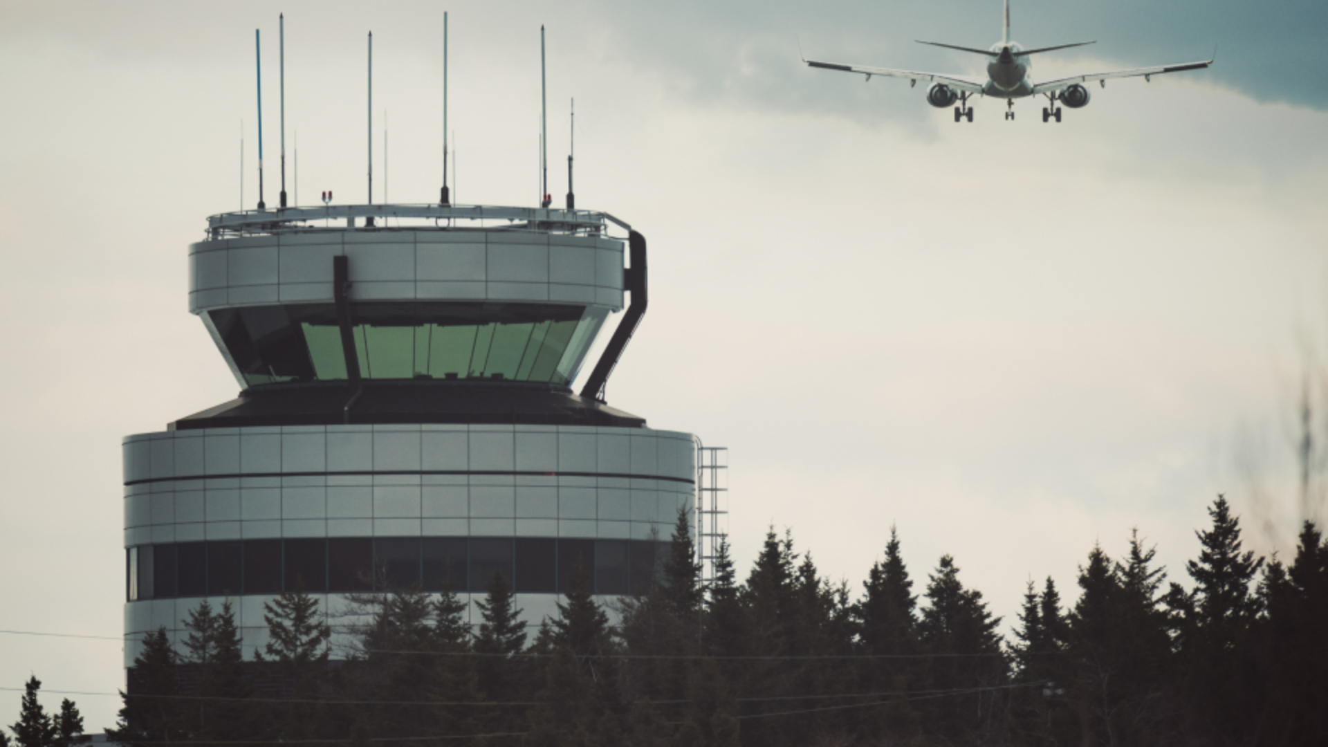 Torre de controle com aeronave em aproximação